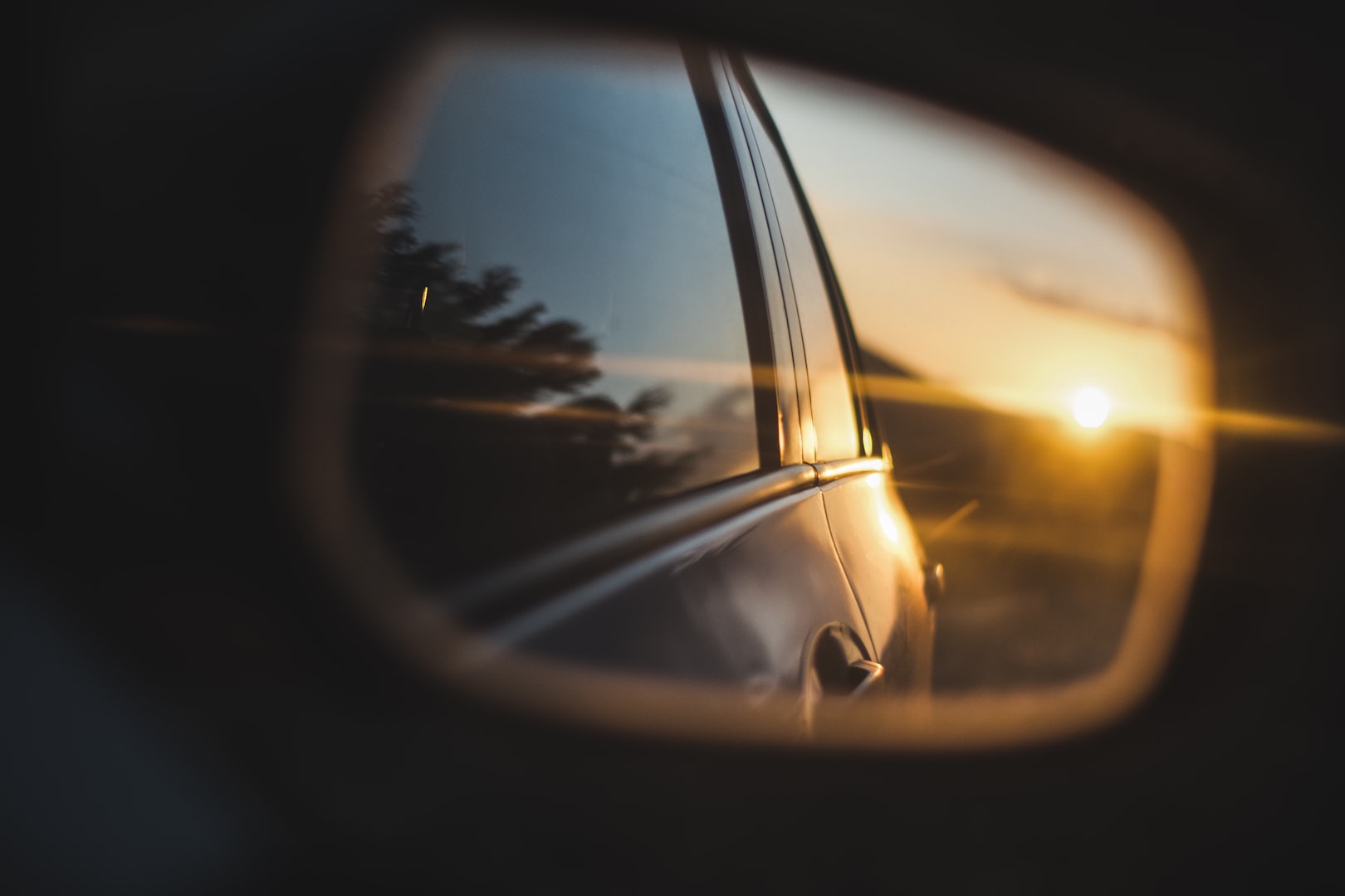 Setting sun in rear view car mirror